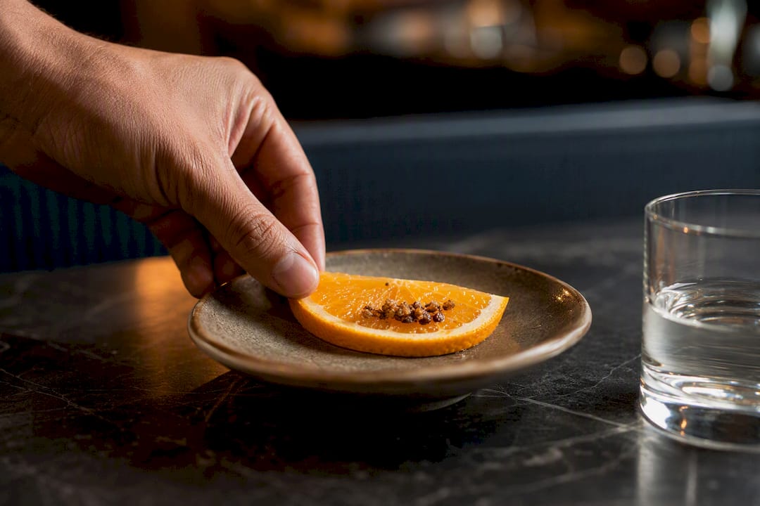 Naranja con sal de gusano junto al mezcal