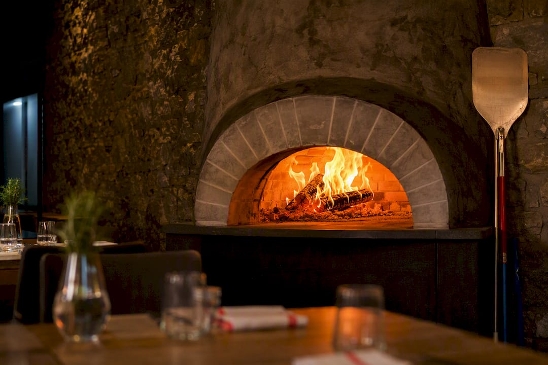 Horno de piedra encendido visto desde el comedor