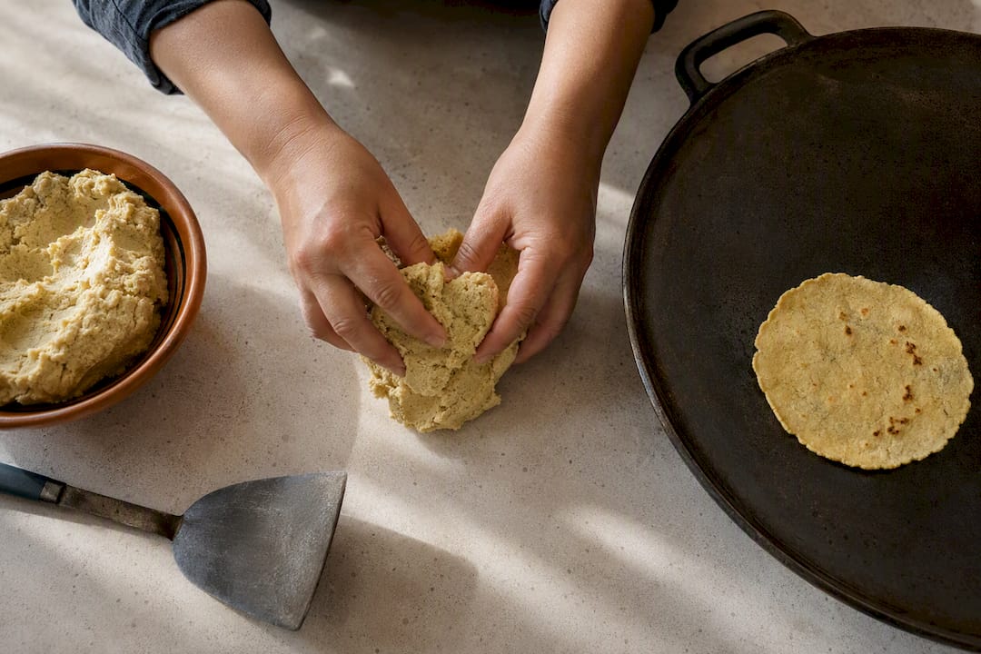 Masa nixtamalizada al lado de un comal caliente