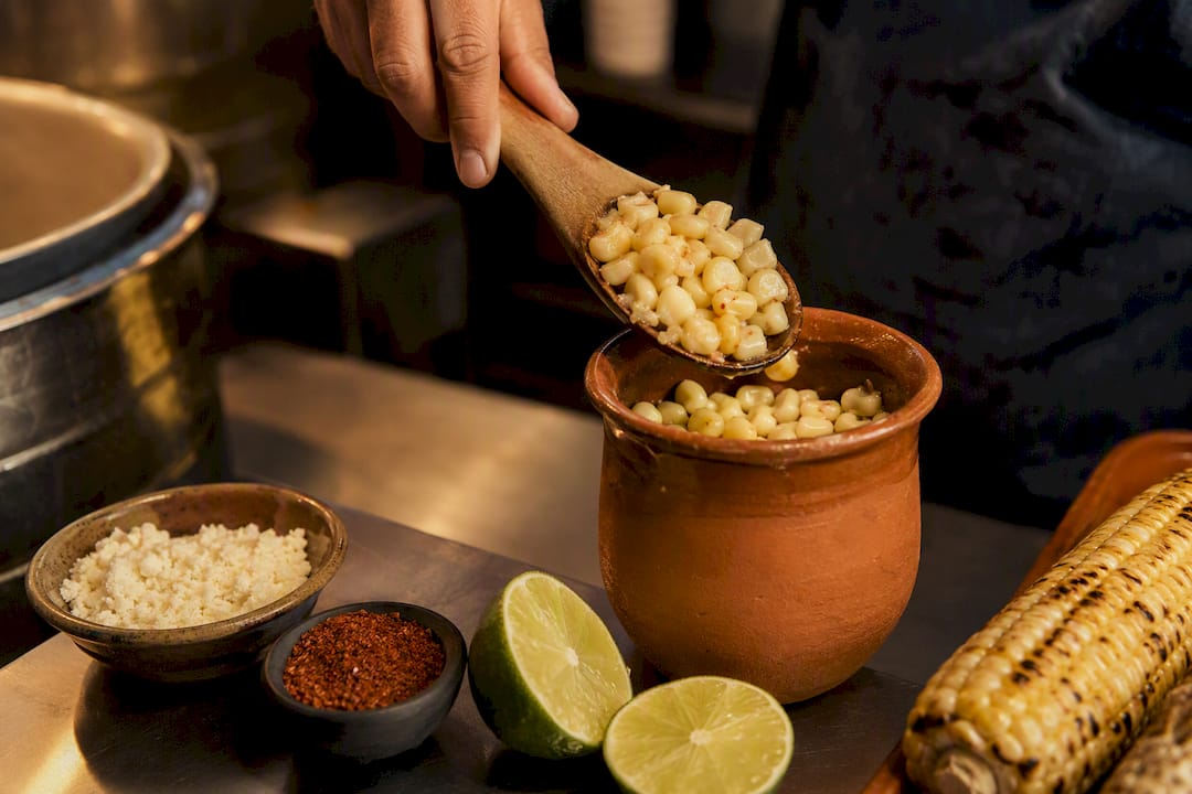 Esquites servidos junto a una mazorca de maíz