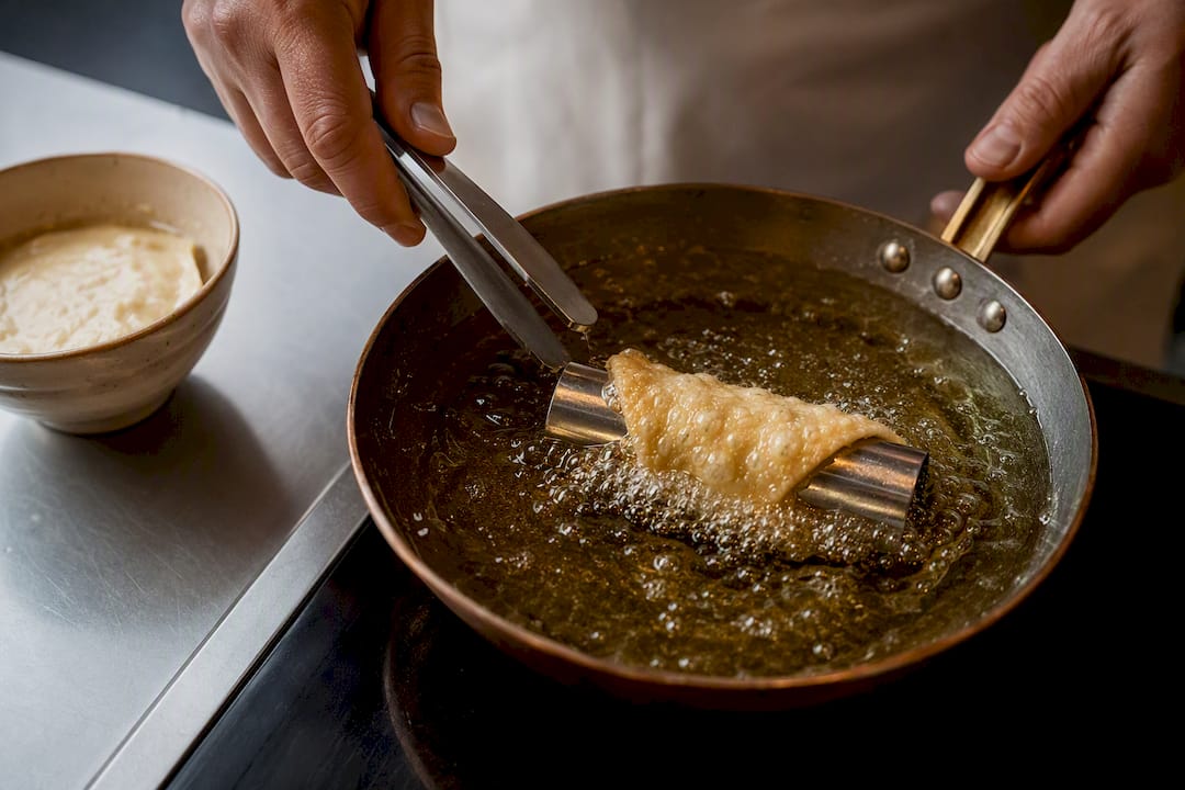 Corteza de cannolo friéndose en aceite