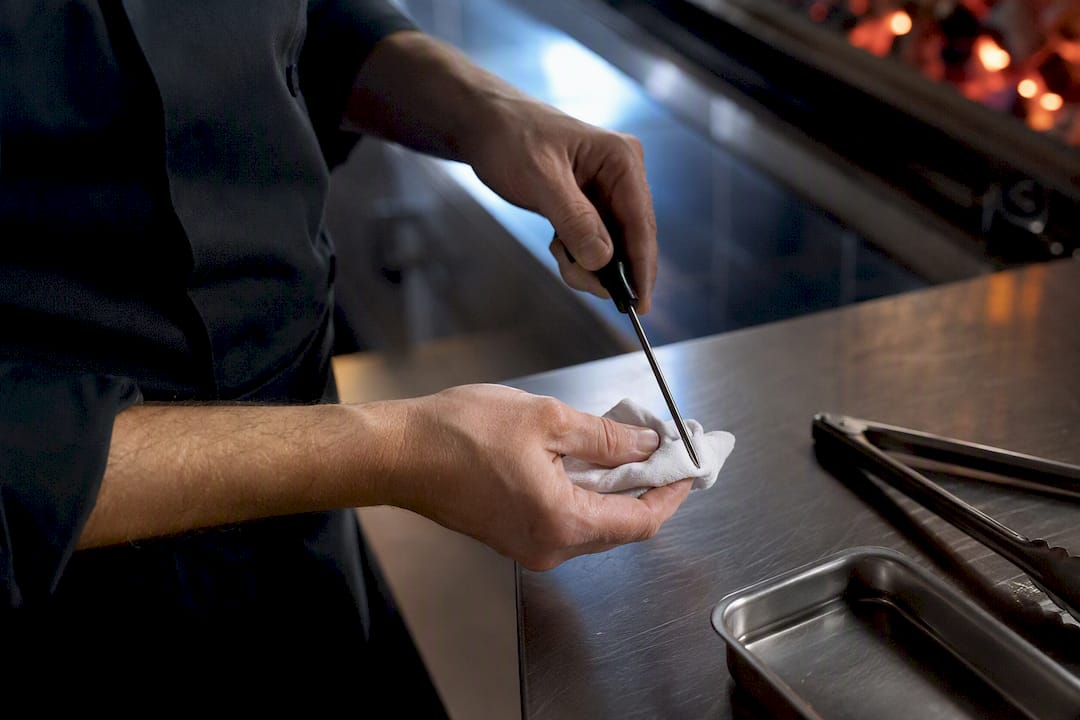 Cocinero secando una sonda térmica limpia