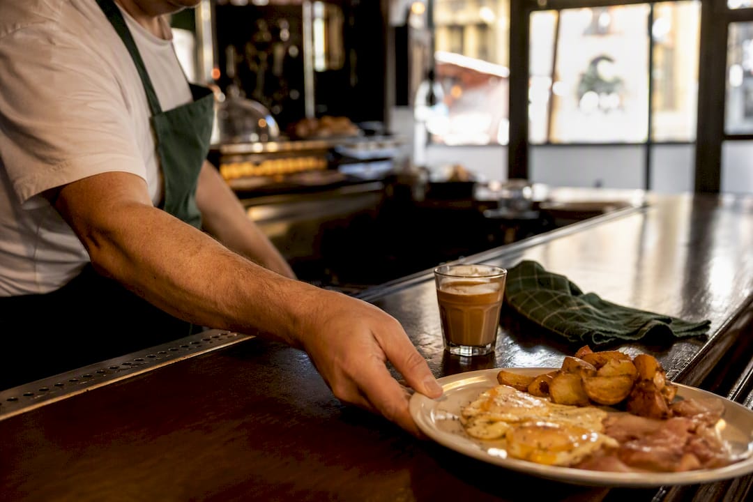 Worker serving a substantial Barcelona fork breakfast