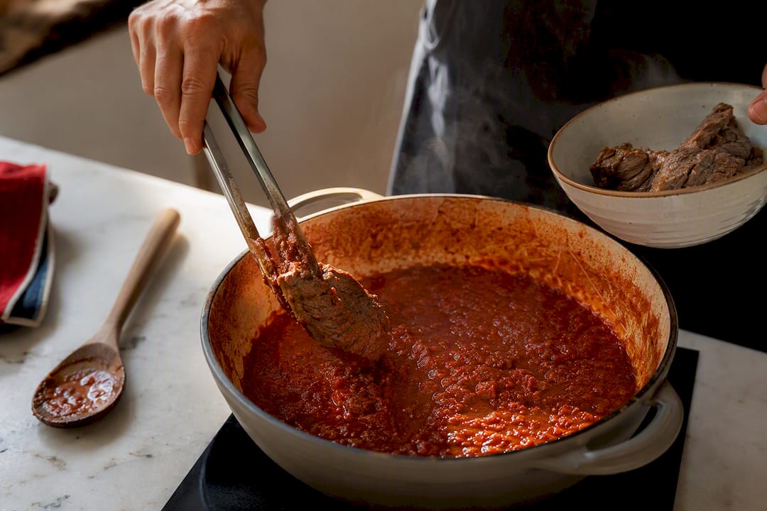 Sugo reduciéndose con la carne separada