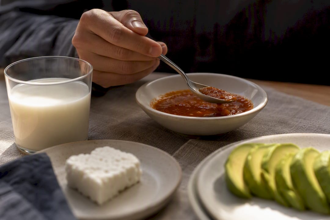 Salsa picante acompañada de leche, queso y aguacate