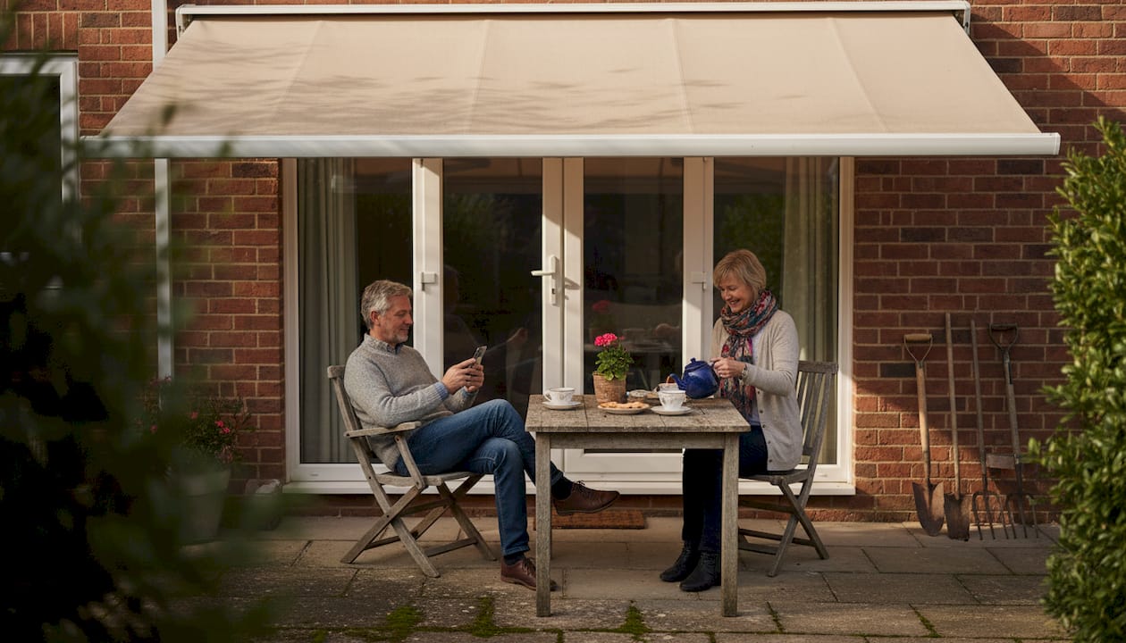 Relaxing under automated awning on terrace
