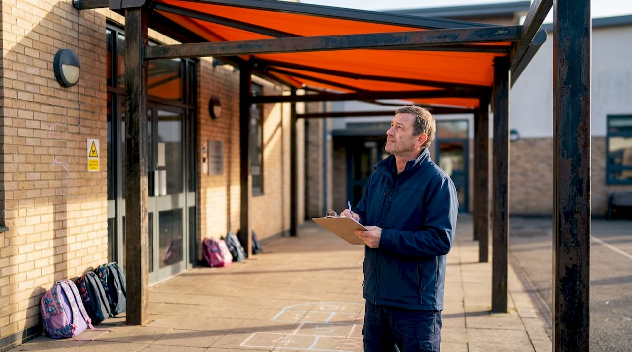 School facility manager inspecting fire-rated awning