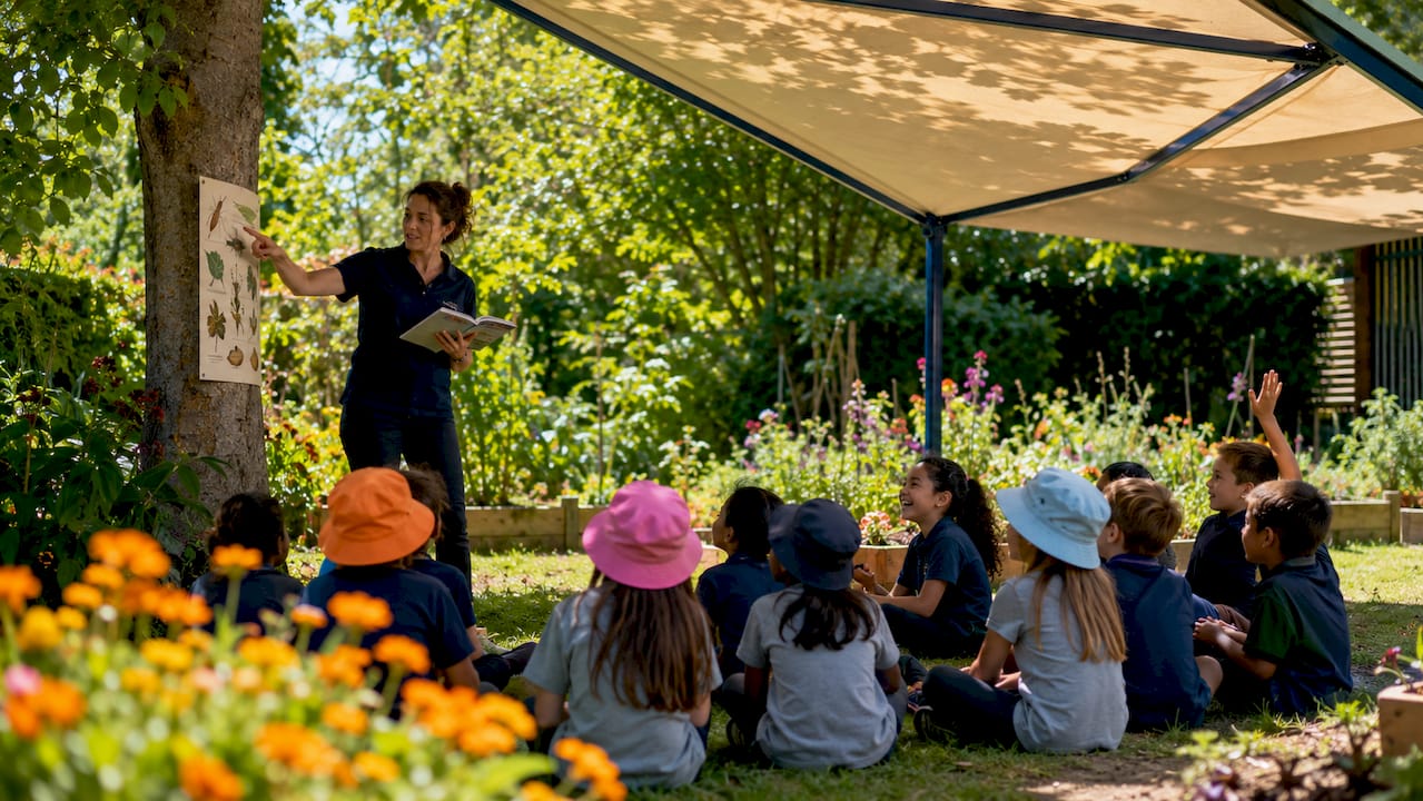 Teacher and students learning under outdoor gazebo