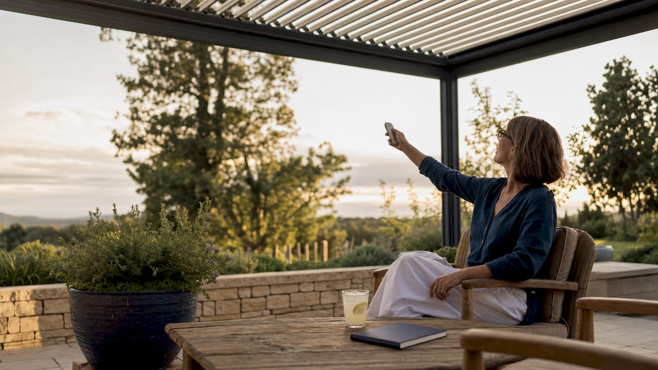Homeowner adjusting aluminium louvered roof outside