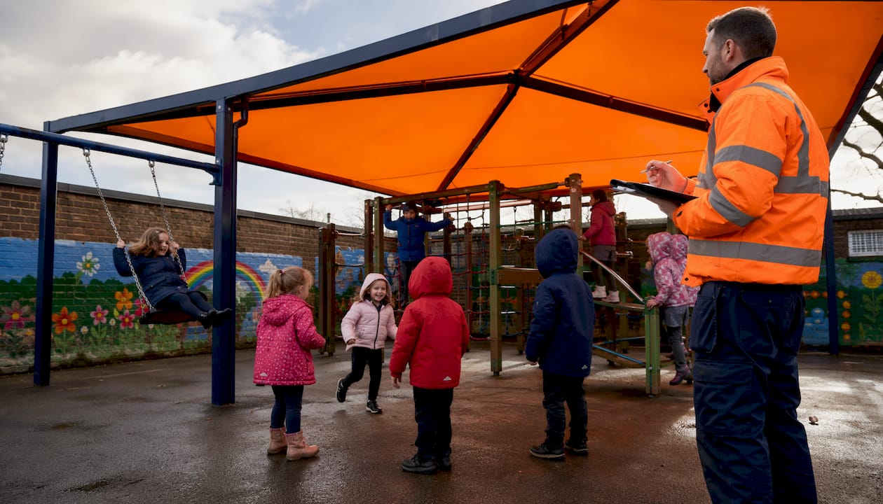 Children playing under school playground canopy in UK