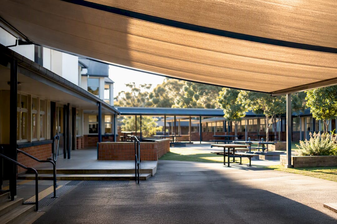 School courtyard with partial retractable awning shade