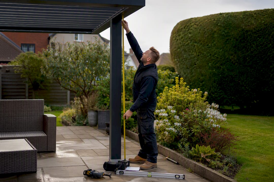 Installer measuring pergola height above decking