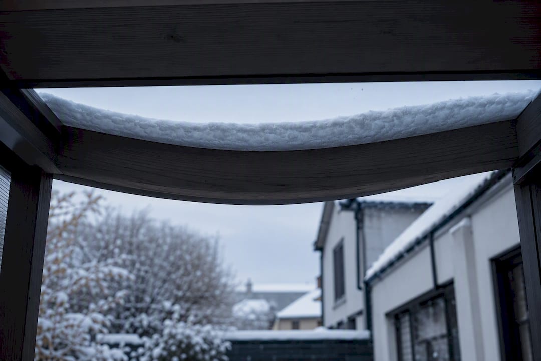 Roof beam visibly bowing beneath snow
