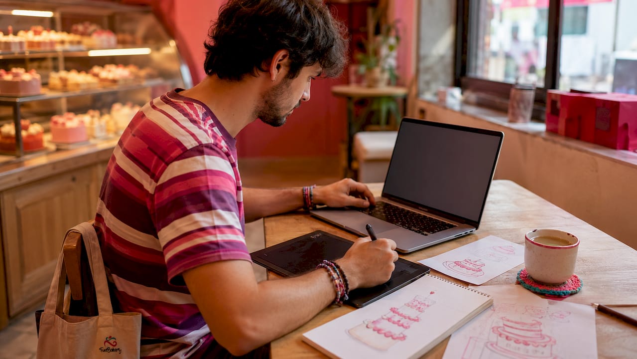 Manos retocando una imagen digital para decorar una tarta
