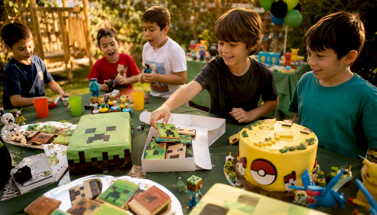 Mesa recheada de bolos e bolachas com temas de videojogos na festa dos miúdos