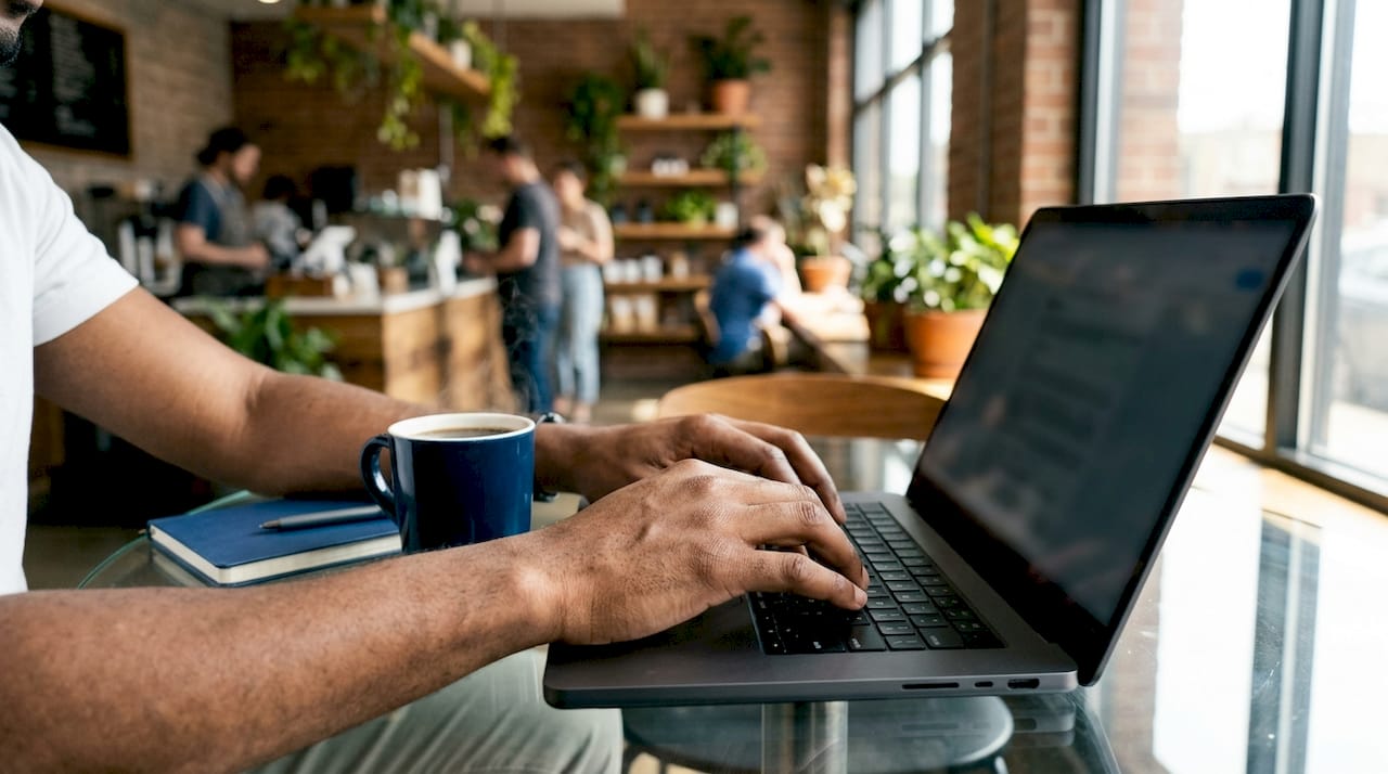 Hands typing on laptop checking passport status online