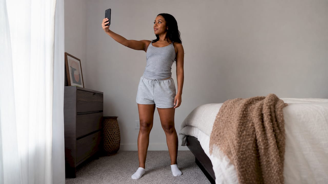Woman taking passport photo at home with smartphone
