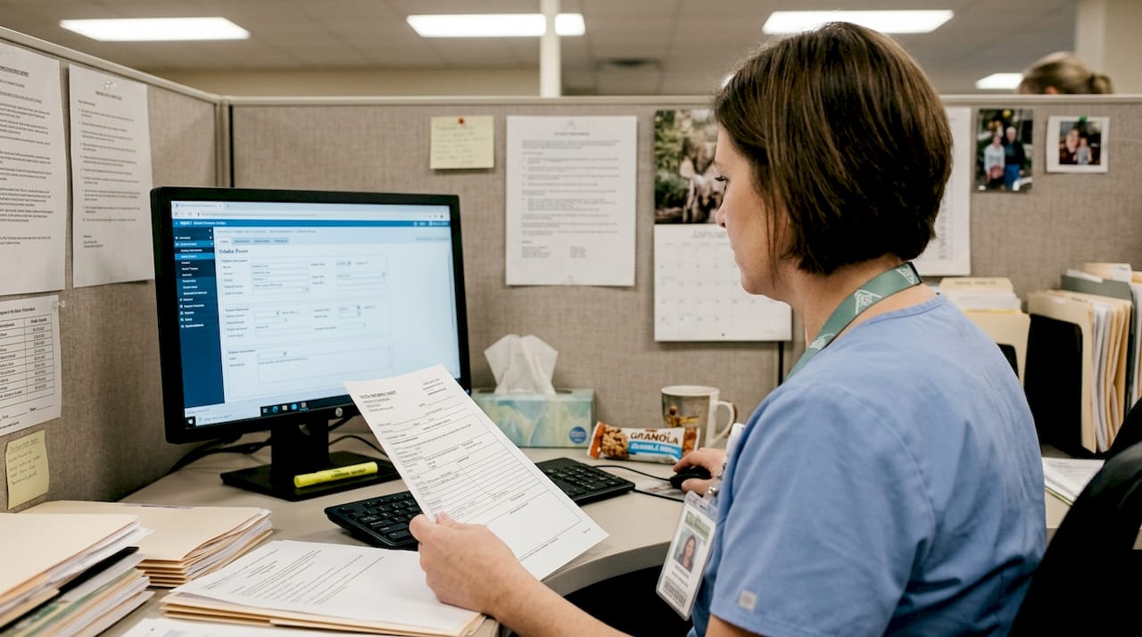 Admissions clerk checking patient data accuracy