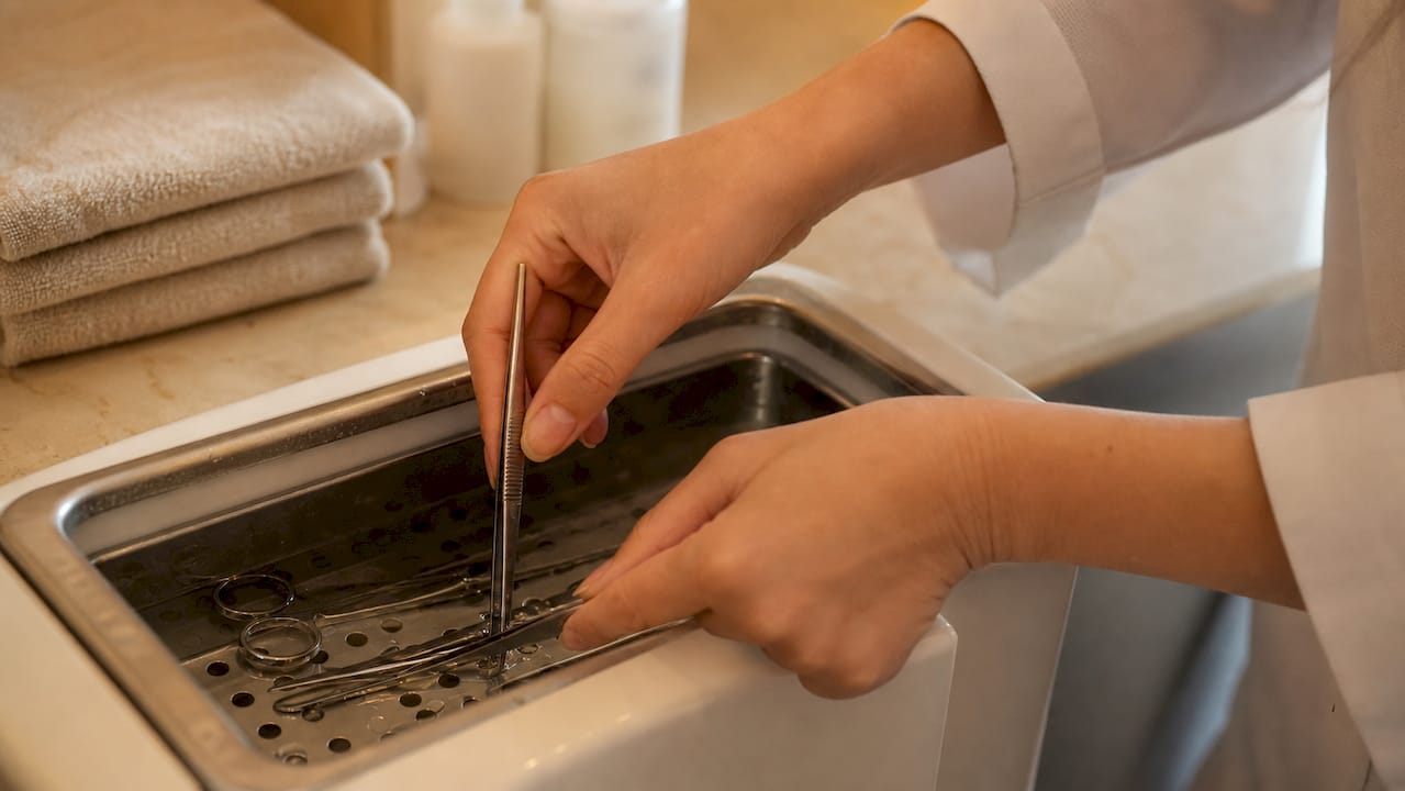 Outils de beauté en cours de désinfection dans un bain stérilisant