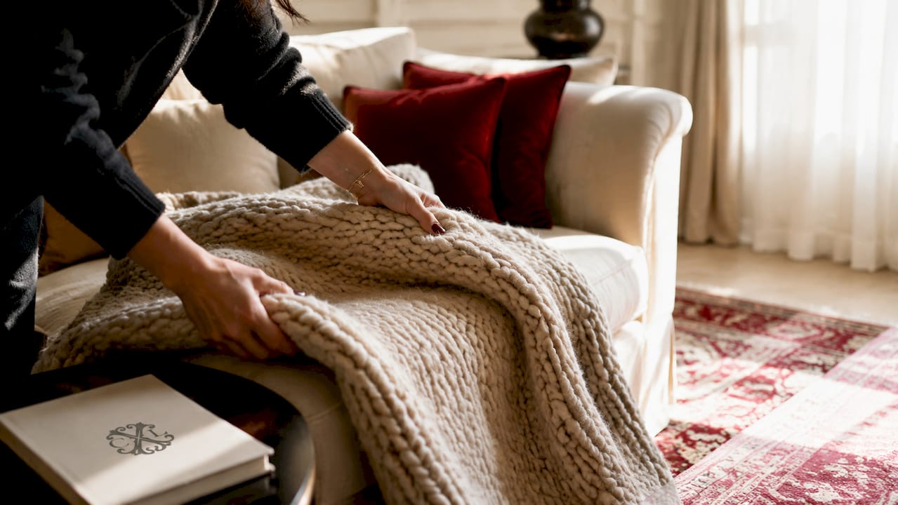 Une main déroule un tapis moelleux pour en apprécier tout le confort.