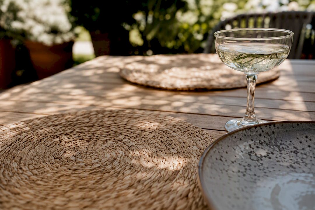 Set de table en bambou tressé, posé sur une table de jardin