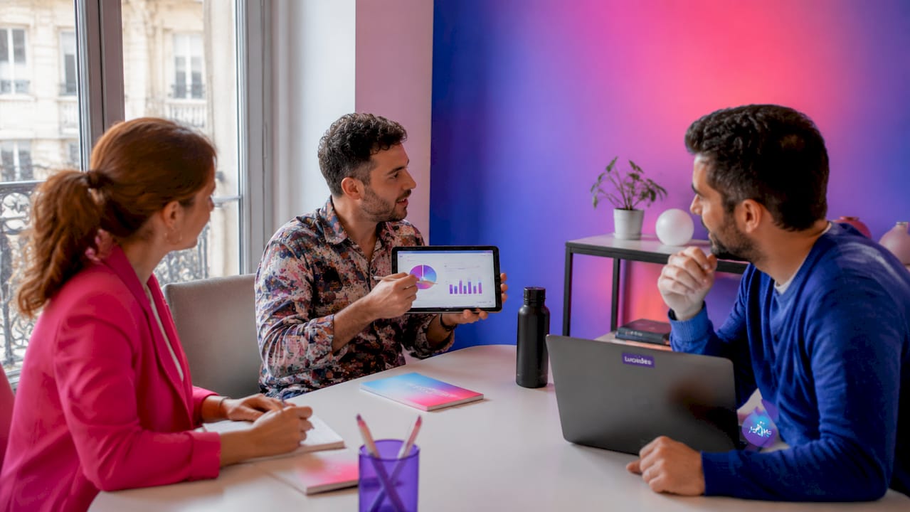 Une équipe se penche sur l’analyse des performances marketing lors d’une réunion de travail.