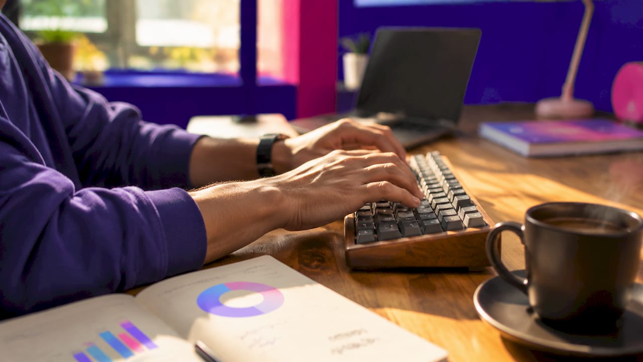 Pourquoi les projets digitaux échouent : causes et solutions 2 Des mains s’activent sur un clavier, plongées dans l’ambiance d’un bureau moderne.