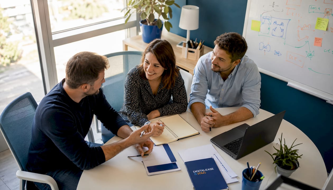 Quelques collaborateurs échangent autour de la table dans un bureau de PME.