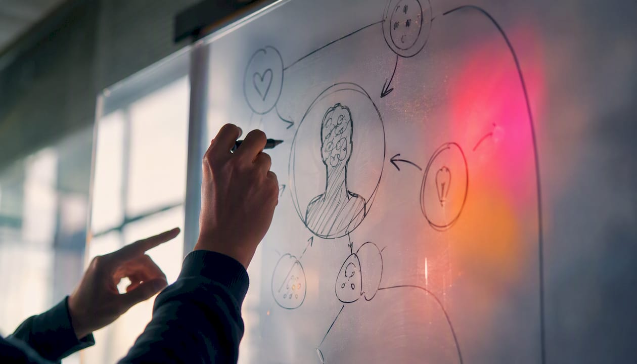 Des mains esquissent le schéma d’un persona en neuromarketing