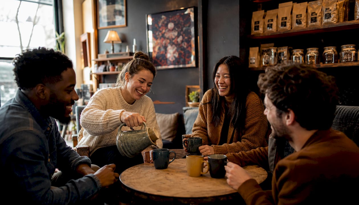 Group enjoying coffee together outdoors around table