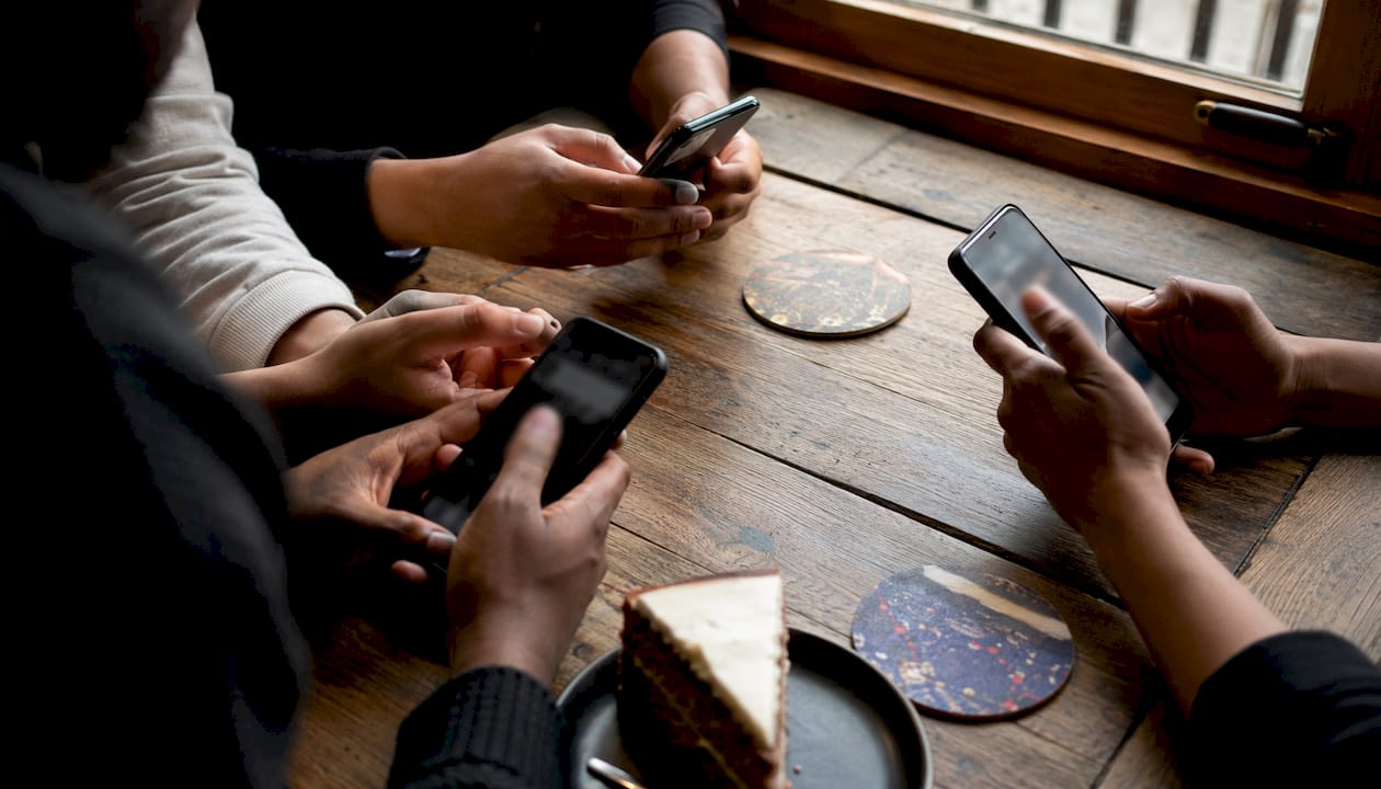 Hands holding smartphones checking social media reviews