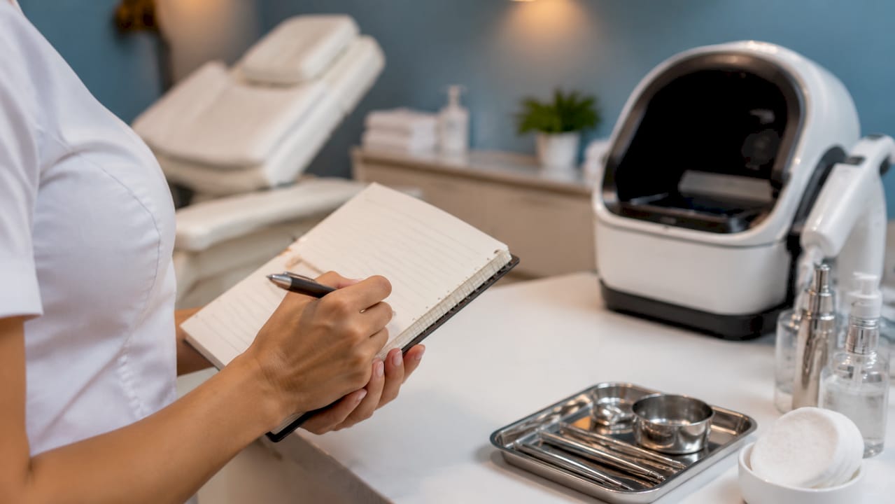 La esteticista repasa su lista de comprobación mientras realiza un tratamiento de belleza.
