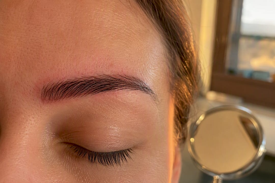 Primer plano de piel clara con enrojecimiento tras microblading