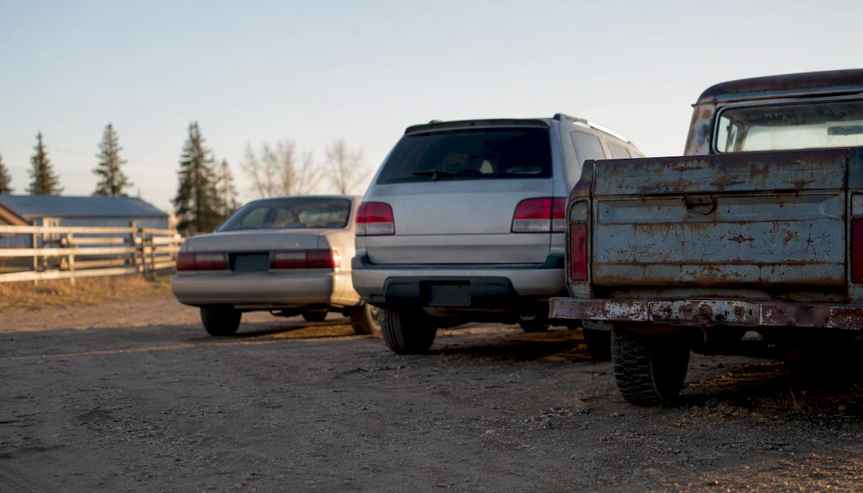 Various anonymous junk vehicle types outdoors
