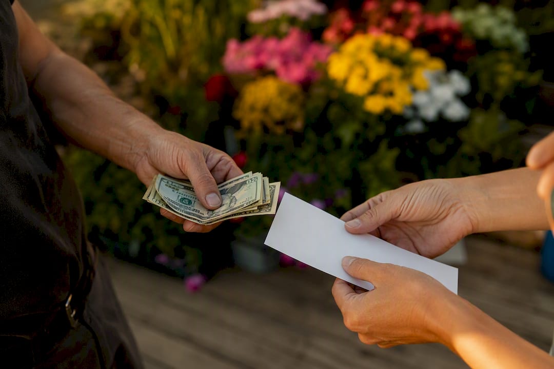 Hands exchanging cash and blank receipt
