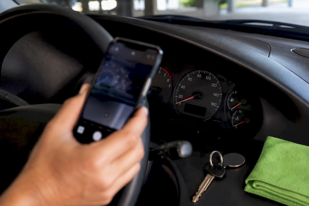 Seller documenting odometer before vehicle pickup
