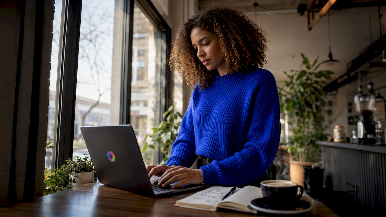 Des mains tapant sur un clavier d’ordinateur dans un espace de coworking.