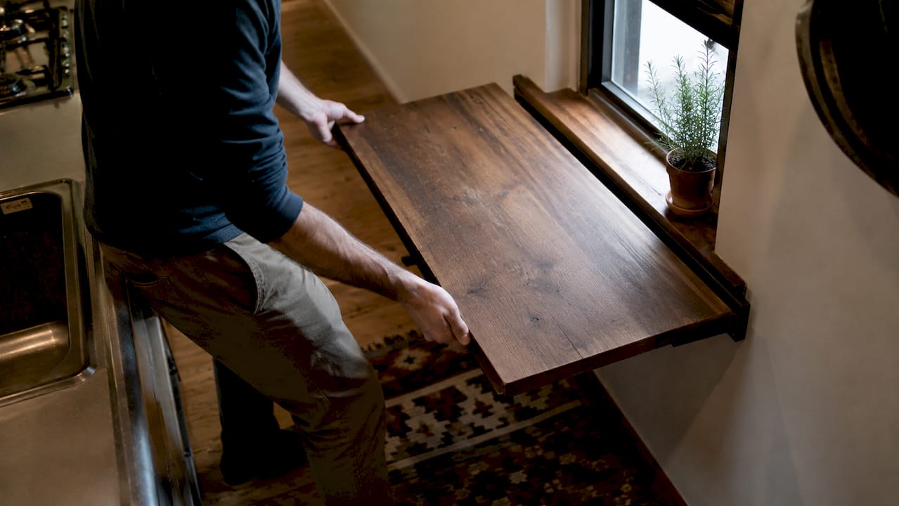 Hands extending console table in small living room