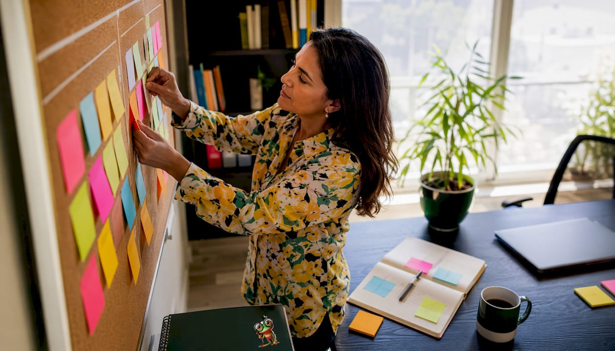 Des mains disposent des post-it illustrant différents styles de management sur une vitre.