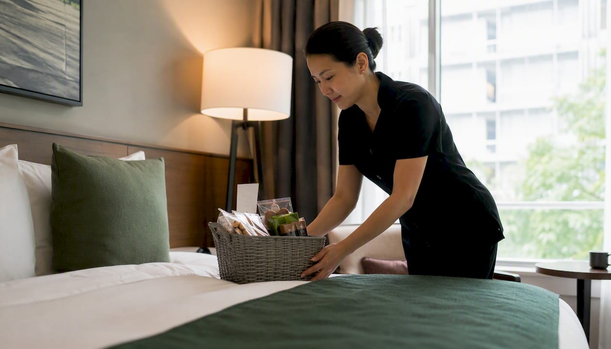 Staff arranging personalized welcome gift in room