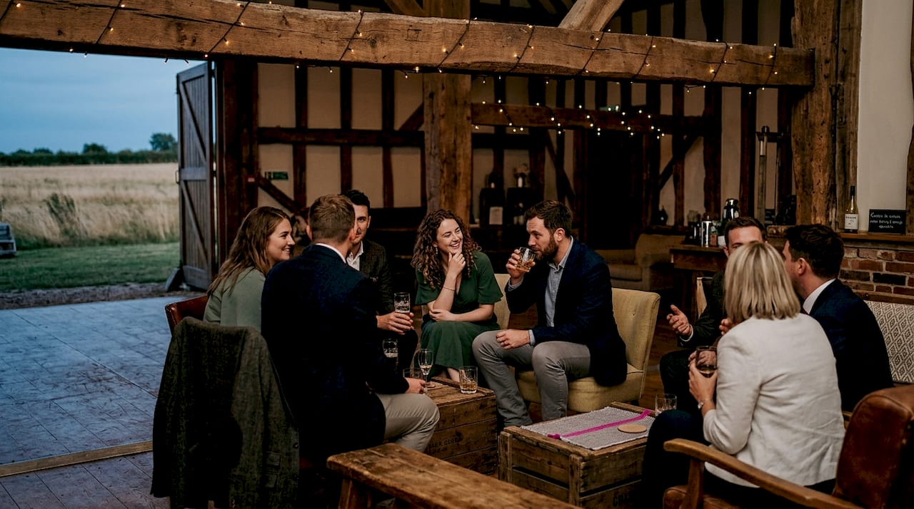 Guests chatting at rustic barn wedding lounge