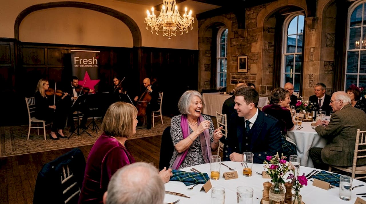 Wedding guests relaxing at live music reception
