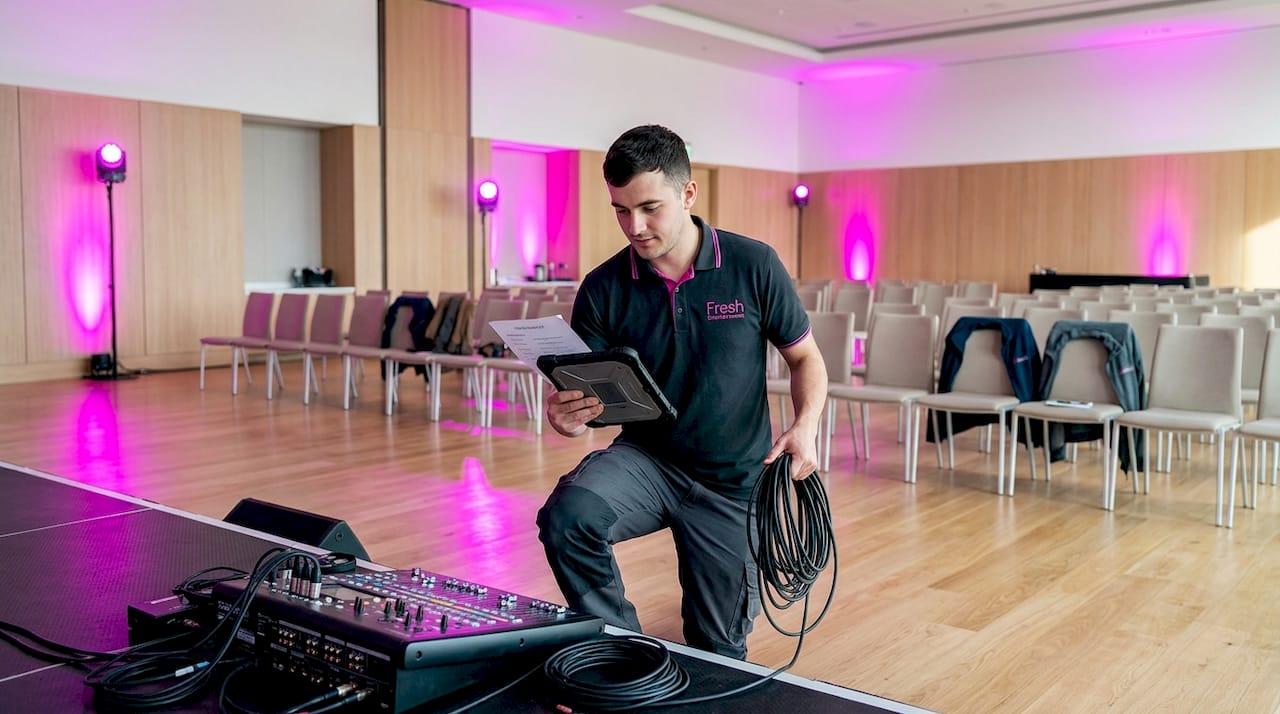 AV technician preparing sound equipment in ballroom