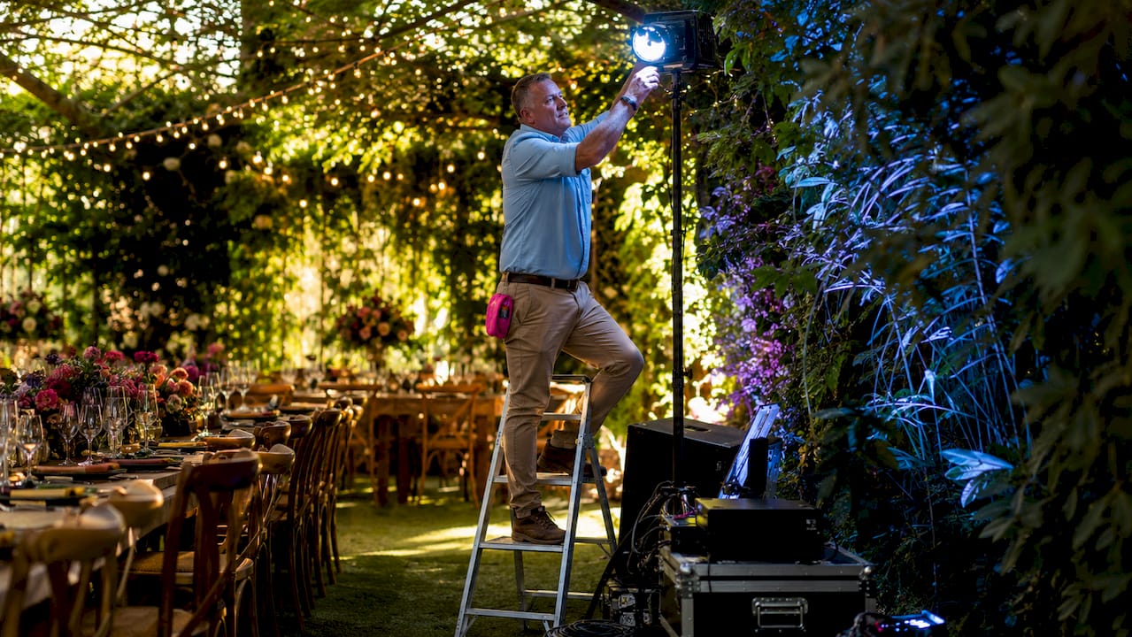 Technician adjusting uplight at wedding
