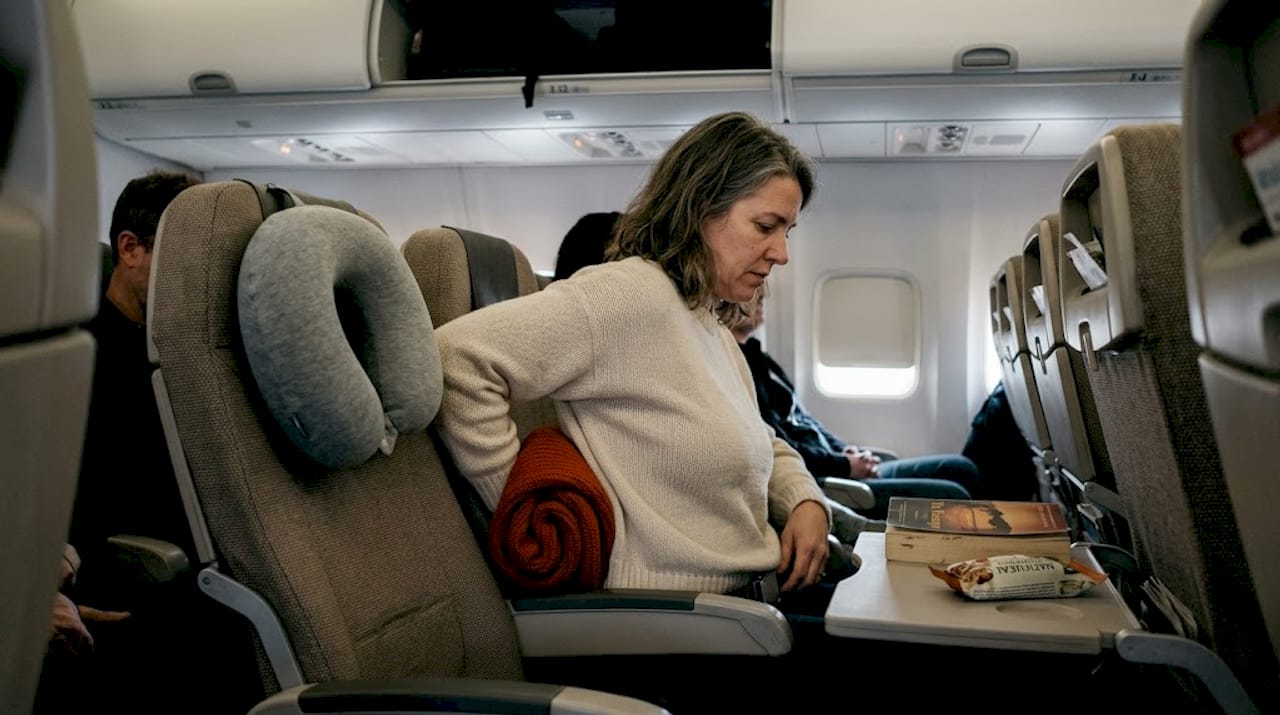 Passenger using sweater for lumbar airplane support