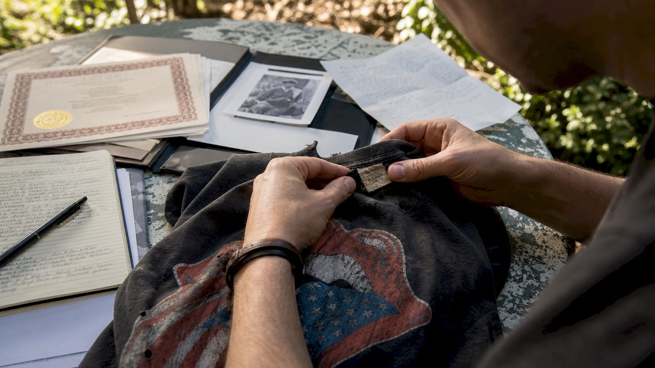 Hands inspecting vintage shirt label and documents