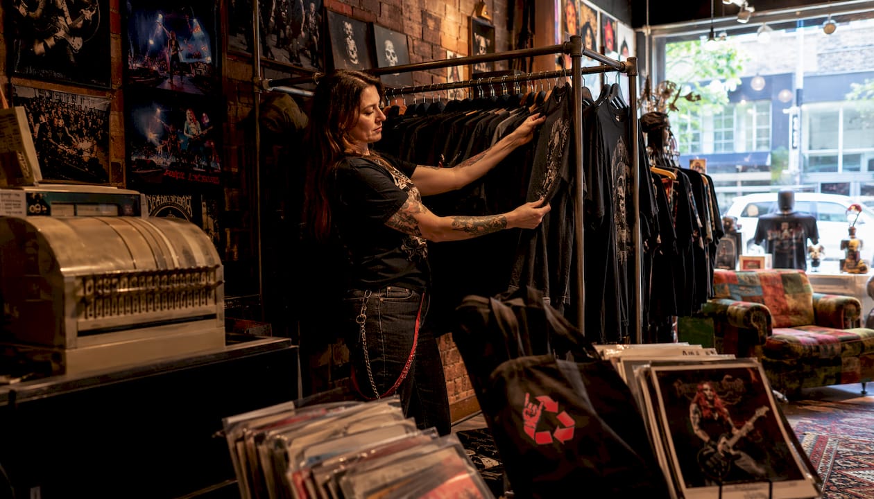 Vintage Metal Store owner arranging rare metal shirts