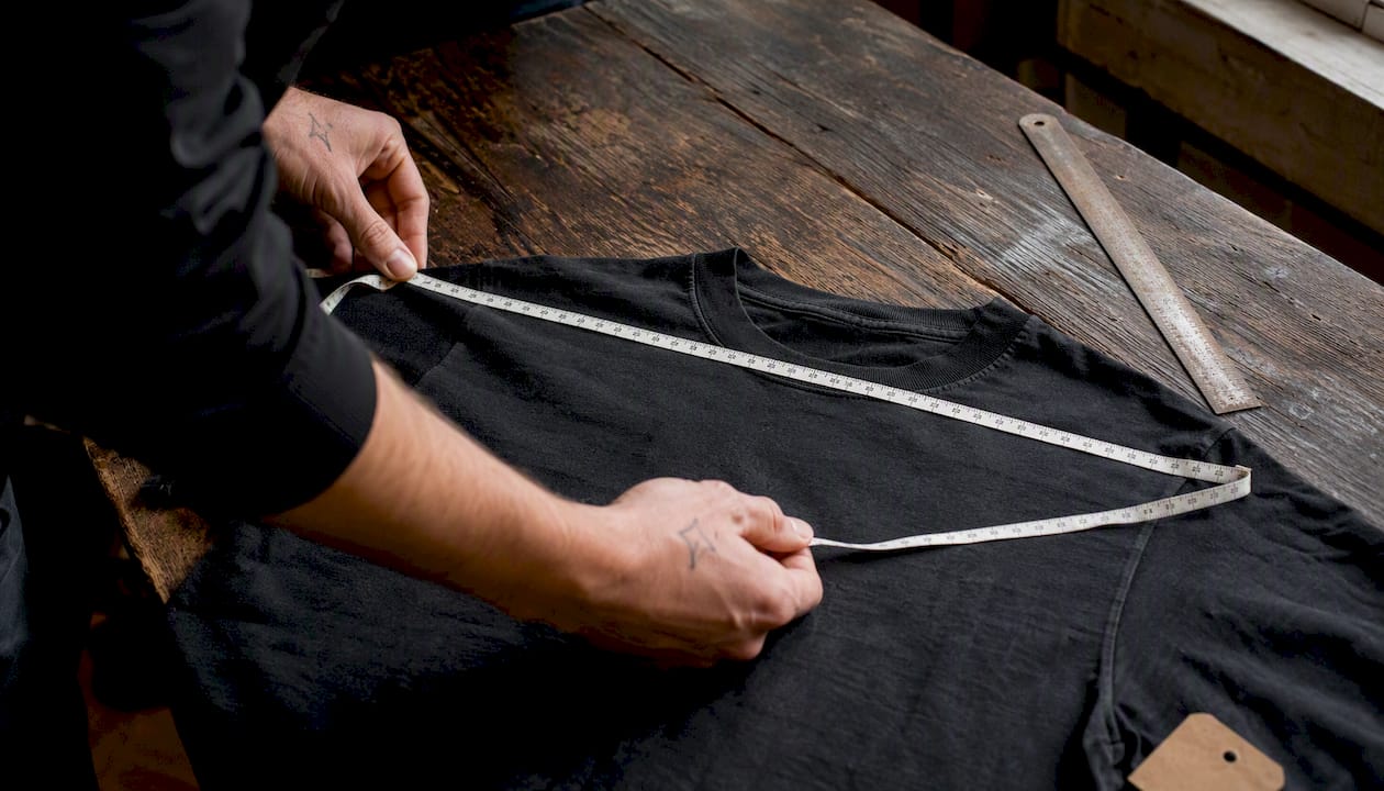 Measuring vintage metal t shirt flat on table