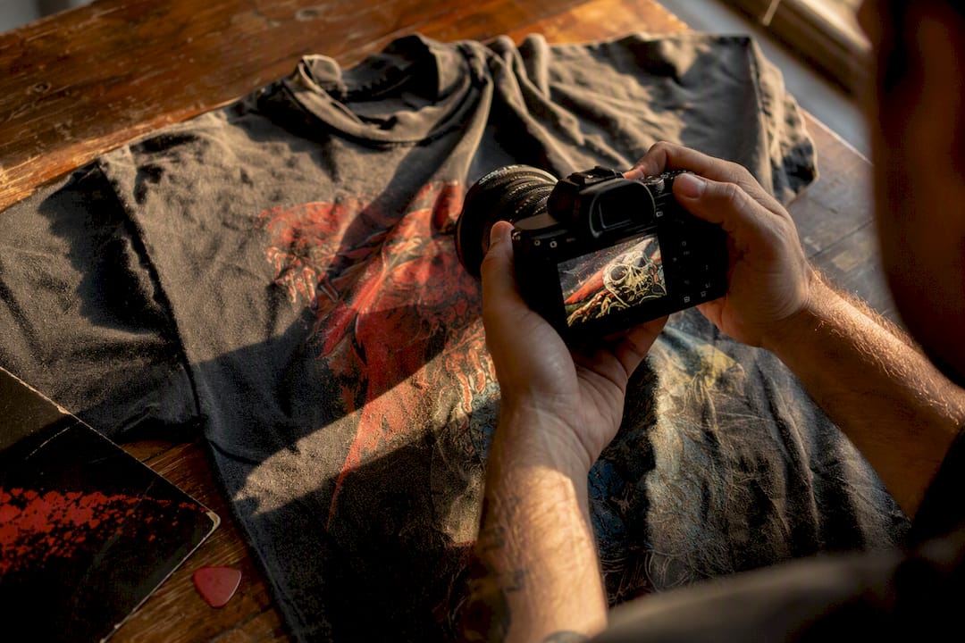 Hands photographing vintage shirt details