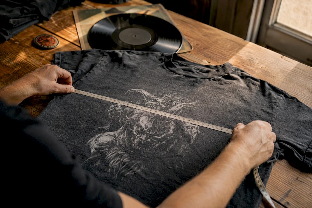 Hands measuring vintage metal tee width